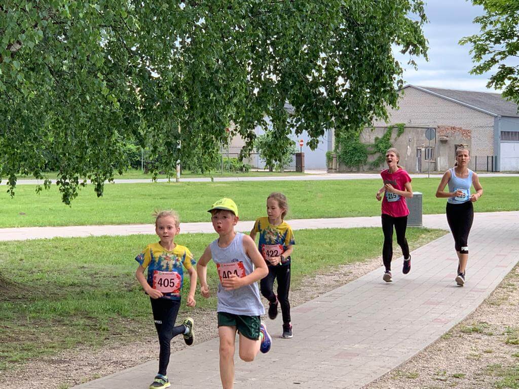 Četri bērni skrien pa trotuāru