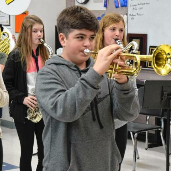 Skolēni pūš trompetes